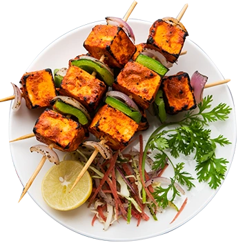 Skewered pieces of grilled tandoori chicken served with green chutney and a side salad